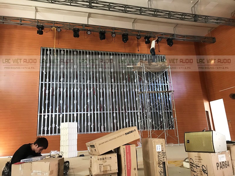 Nhân viên kỹ thuật Lạc Việt Audio đang treo đèn